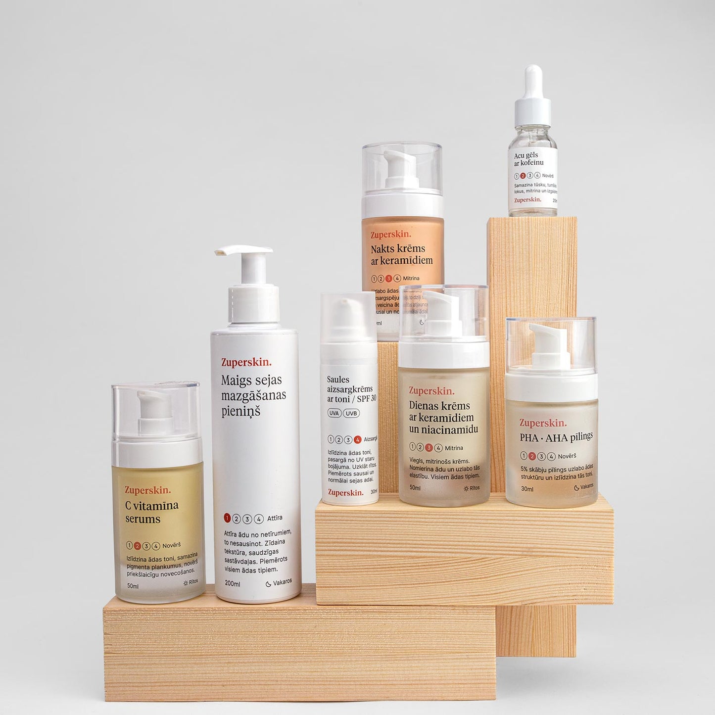 Zuperskin visi sejas kopšanas produkti izkārtoti uz koka statīviem